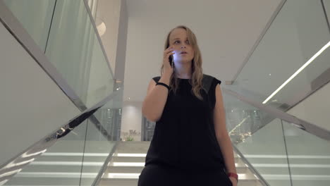 Eine-Junge-Frau-Spricht-Mit-Einem-Smartphone,-Während-Sie-Die-Treppe-Hinuntergeht