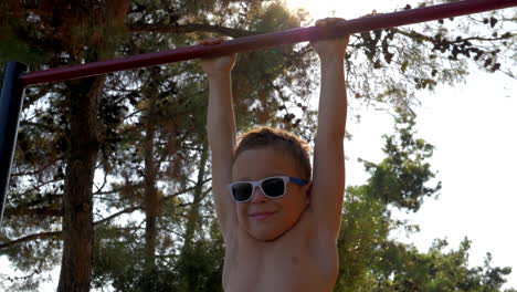 Child-on-pull-up-bar-at-sports-ground-outdoor