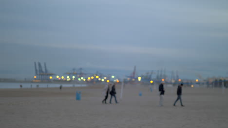 People-walking-on-the-beach-on-a-cold-day