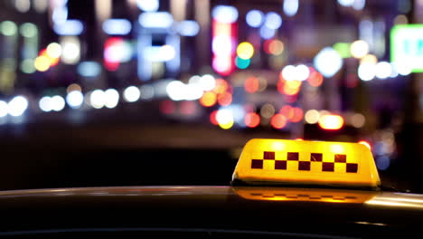 Timelapse-of-city-traffic-at-night-behind-taxi-sign