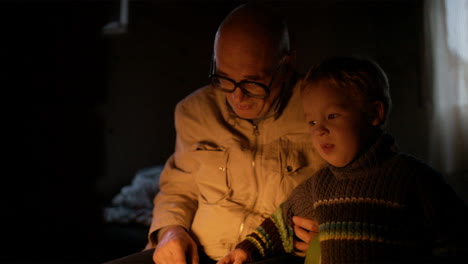 Grandfather-and-grandson-near-fire-at-home