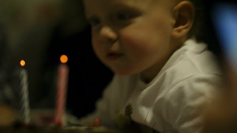 Kleiner-Junge-Bläst-Zwei-Kerzen-Auf-Seiner-Geburtstagstorte-Aus