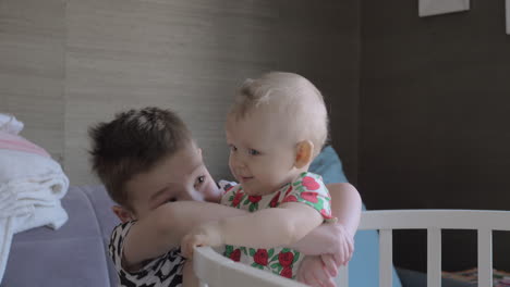 A-boy-hugging-his-baby-sister-in-a-crib