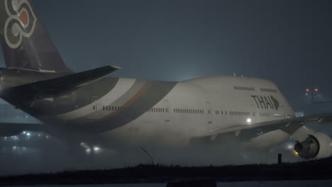 Boeing-747-Der-Thailändischen-Fluggesellschaft-Auf-Der-Landebahn-In-Der-Winternacht