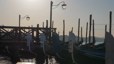 Gondolas-moored-at-the-dock-with-wooden-pier-Venice-Italy