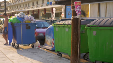 Mit-Dem-Baby-Auf-Der-Straße-Laufen,-Während-Die-Müllcontainer-Voll-Sind