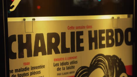 Banner-Des-Satirischen-Magazins-Charlie-Hebdo-In-Der-Nachtstraße-Von-Paris,-Frankreich