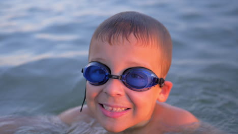 Smiling-child-in-goggles-swimming-in-the-sea