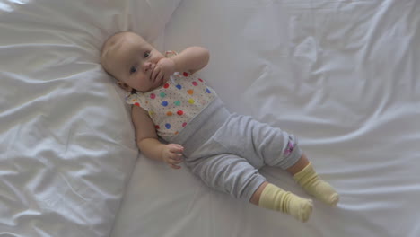 Quiet-baby-girl-on-the-bed-at-home