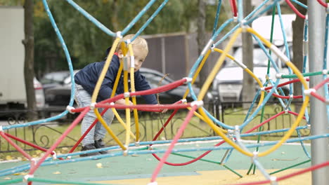 Happy-little-boy-climbing-on-playground-equipment