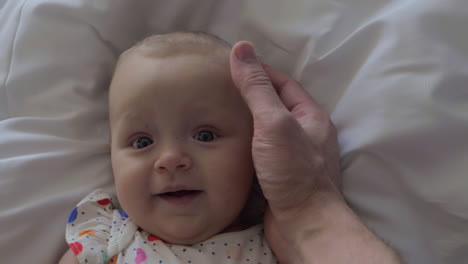 A-six-months-old-baby-girl-smiling-to-father-touch