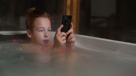 Junge-Im-Badezimmer-Im-Freien-Mit-Mobiltelefon