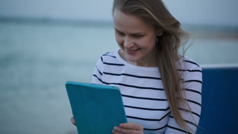 Young-woman-using-tablet-PC-by-the-sea