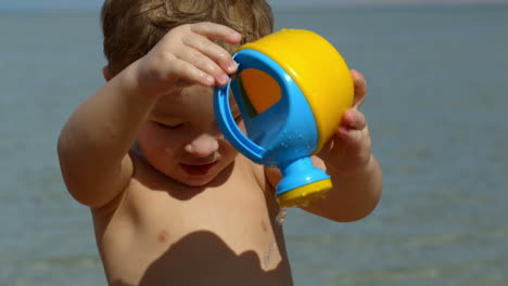 Little-boy-having-fun-with-toy-waterpot