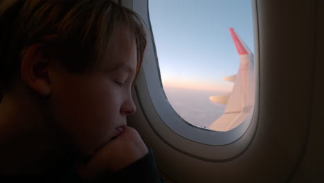 Müder-Junge,-Der-Aus-Dem-Flugzeugfenster-Schaut