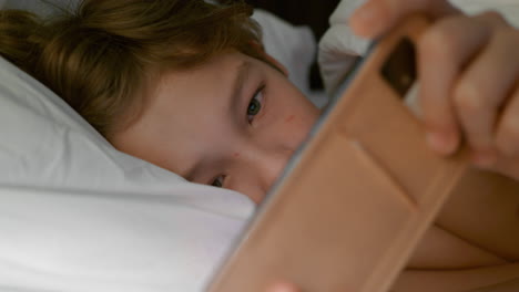 Junge-Mit-Smartphone-Im-Bett-Nach-Dem-Aufwachen