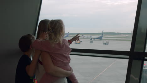 Mutter-Mit-Neugierigen-Kindern,-Die-Am-Flughafen-Auf-Ihren-Flug-Warten