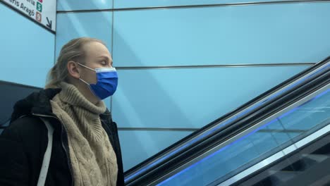 Commuter-in-medical-mask-on-escalator-in-subway