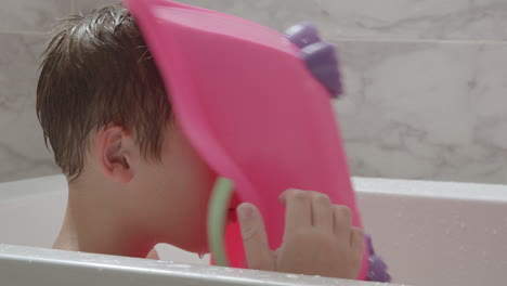 Fantasievolles-Kind,-Das-Eine-Spielzeugbadewanne-Als-Helm-Benutzt-Und-In-Der-Badewanne-Spielt