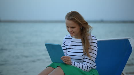 Woman-with-touchpad-by-the-sea