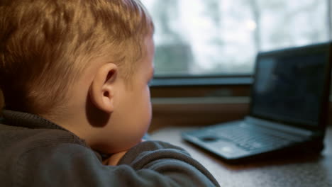 Little-boy-watching-video-on-laptop-in-the-train