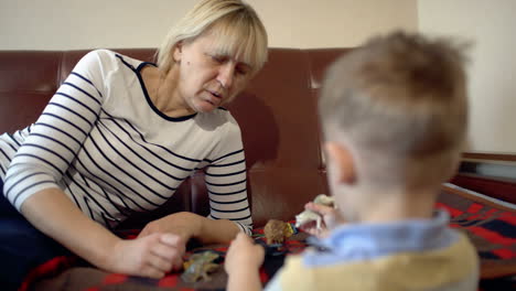 Grandmother-and-granson-playing-with-toys-on-the-sofa