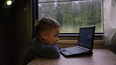 Niño-En-El-Tren-Viendo-Videos-En-Una-Computadora-Portátil
