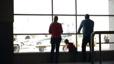 Junge-Familie-Beobachtet-Flugzeuge-Auf-Einem-Flughafen