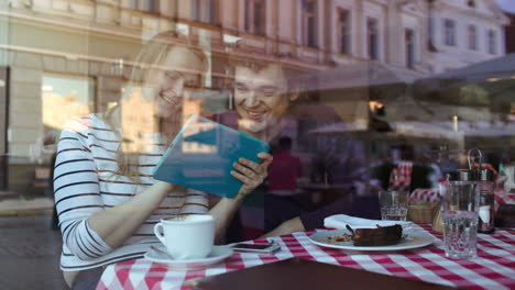Glückliches-Junges-Paar-Mit-Tablet-PC-In-Einem-Café
