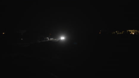 Bright-headlamps-lights-of-a-moving-car-at-night