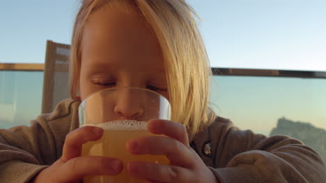 Funny-child-drinking-juice-outdoors