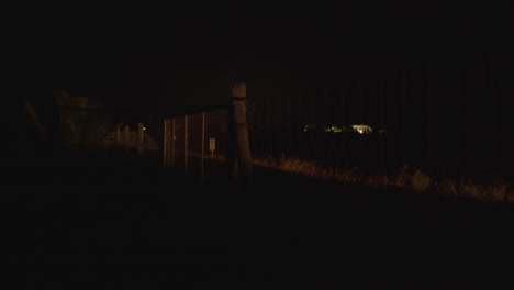 Car-on-the-country-road-with-fence-alongside-night-view