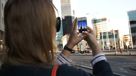 Woman-in-the-city-taking-pictures-with-her-smartphone