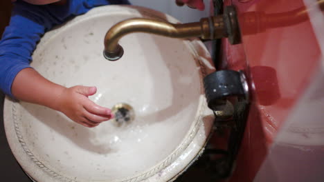 Kind-Wäscht-Hände-In-Vintage-Waschbecken
