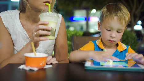 Mother-and-son-with-pad-in-cafe