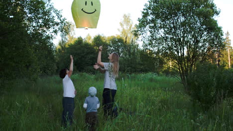 Mother-with-two-sons-flying-smiling-fire-lantern