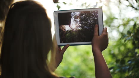 Woman-taking-pictures-of-nature-with-a-tablet-computer