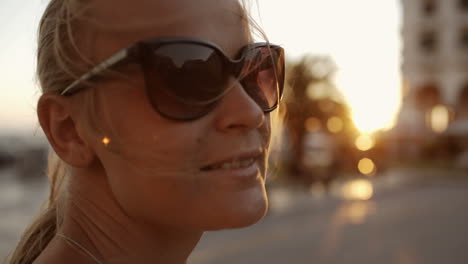 Smiling-woman-in-sunglasses-outdoor-during-sunset