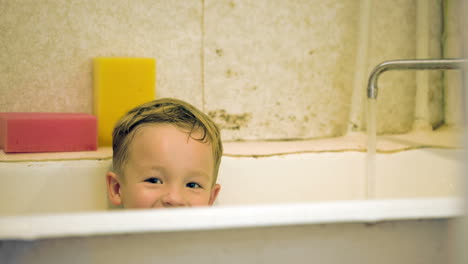Little-smiling-boy-sitting-in-bath
