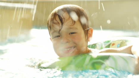 Glücklicher-Kleiner-Junge,-Der-Mit-Gummiring-Im-Pool-Schwimmt