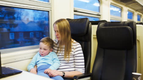 Mother-and-her-son-watching-movie-on-laptop-in-the-train