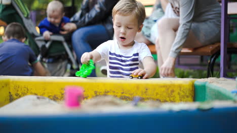 Child-playing-with-toys-in-sand-pit