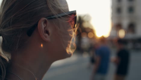 Woman-in-sunglasses-looking-into-distance-during-sunset