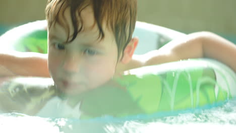 Nettes-Kind,-Das-Spaß-Beim-Schwimmen-Mit-Gummiring-Im-Pool-Hat