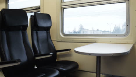 Two-empty-seats-with-table-in-the-moving-train