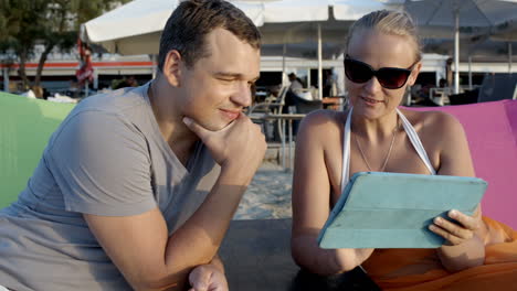 Man-and-woman-with-tablet-computer-on-the-beach