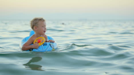 Boy-with-rubber-ring-swimming-in-sea