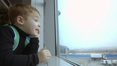 Mother-and-son-at-airport-spending-time-looking-out-the-window