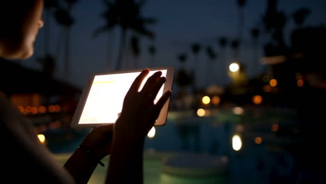 Woman-tourist-with-pad-on-tropical-resort-in-late-evening