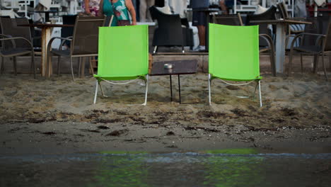 Two-empty-chaise-lounges-with-table-on-the-beach